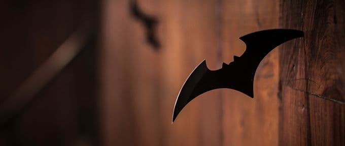 batman batarang is stuck in a wooden wall