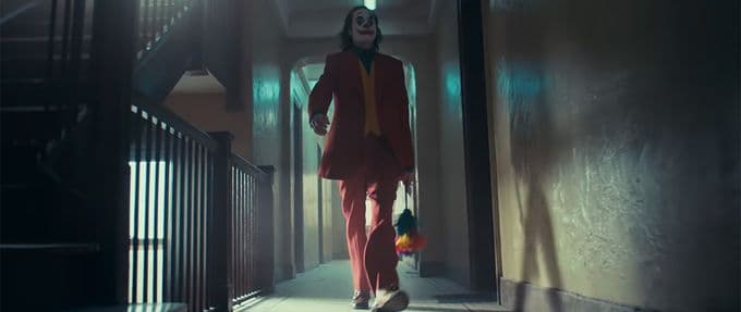 This screenshot depicts Joaquin Phoenix in the Joker trailer, holding flowers